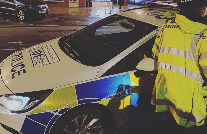 Police car and police officer on roadside