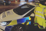 Police car and police officer on roadside