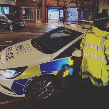 Police car and police officer on roadside